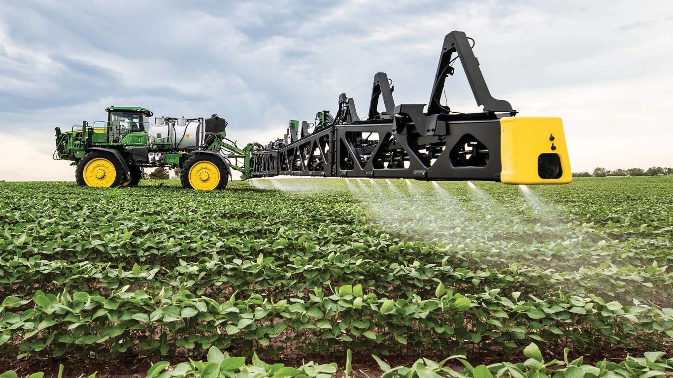 Pohľad zblízka na rameno postrekovača John Deere na otvorenom poli.