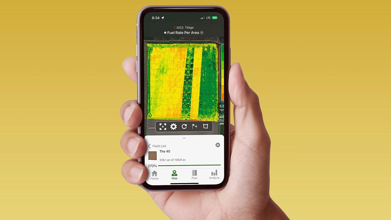 Ruka držiaca smartfón so zobrazením operačného centra John Deere Operations Center s údajmi o množstve paliva.