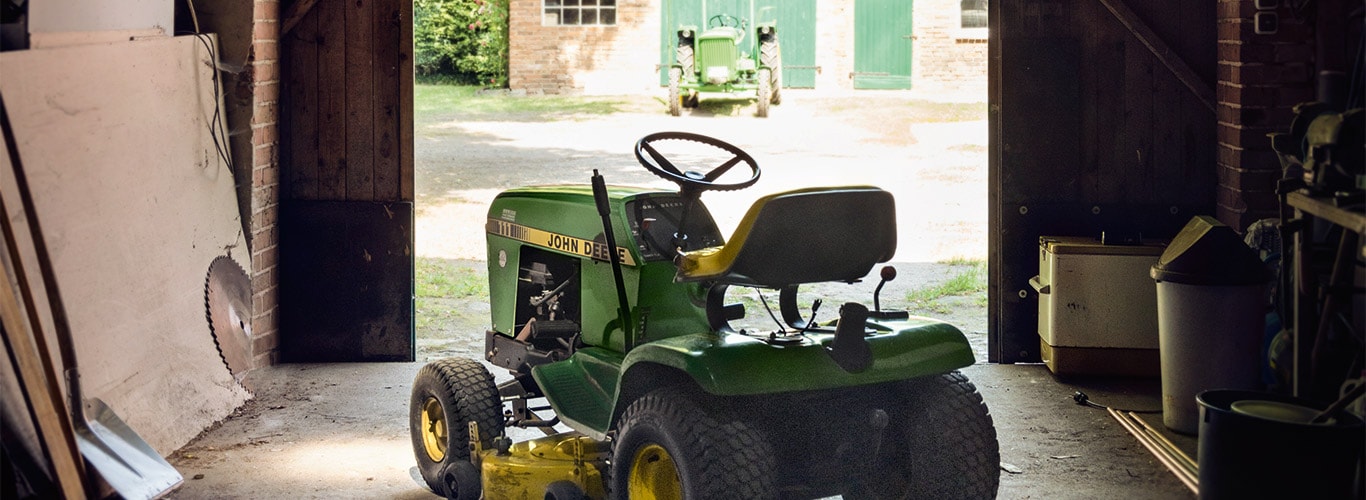 Stará traktorová kosačka, stodola, majiteľ domu