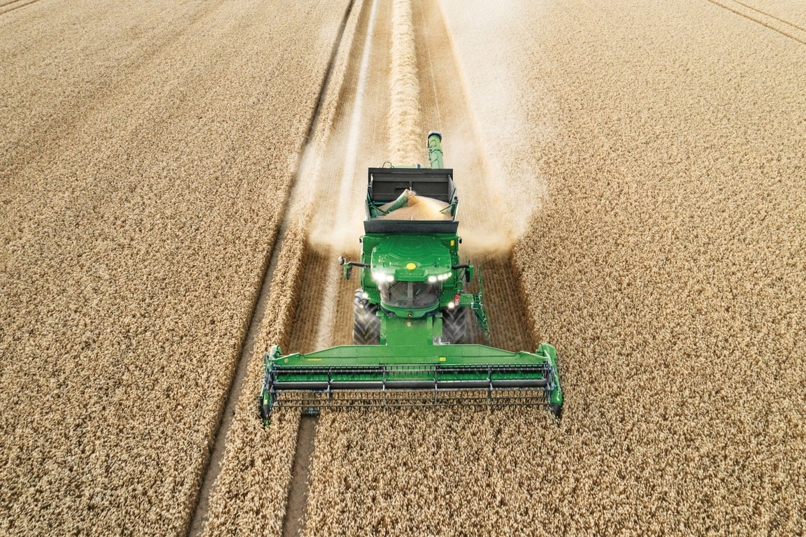 Kombajn vykladá obilie počas žatvy pšenice s efektívne pracujúcim žacím valom