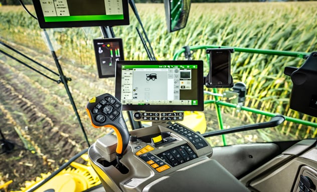 Samohybný žací stroj na krmivo F9 700 nakladajúci príves Joskin ťahaný traktorom John Deere 6R