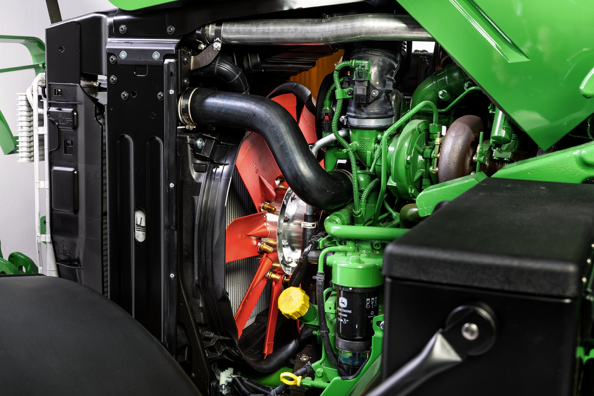 Detailný pohľad na motorový priestor John Deere radu 6M s dôrazom na chladiacu sústavu a komponenty motora.
